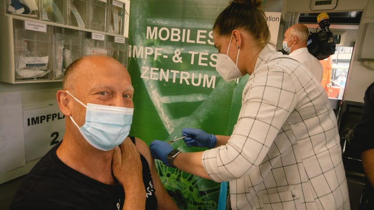 Ein Mann erhält bei einer Massenimpfung in Köln Impfstoff (Archivbild). In Deutschland sind die Infektionszahlen weiterhin sehr hoch.