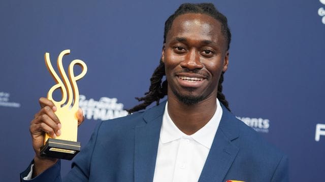 Der Schauspieler Eugene Boateng zeigt seinen Preis.