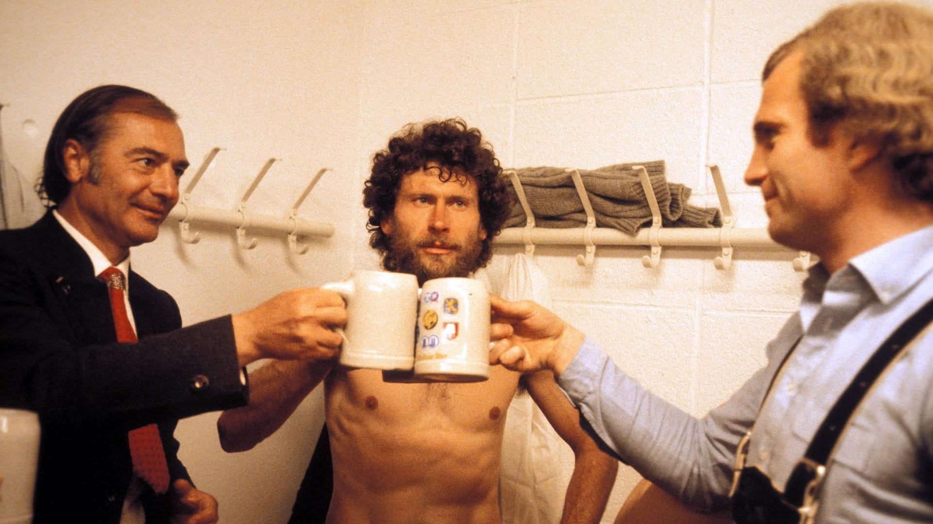 Trainer, Starspieler und Manager: Pal Csernai (v. l.), Paul Breitner und Uli Hoeneß stoßen in der Umkleidekabine des FC Bayern auf den Gewinn der Deutschen Meisterschaft 1980 an.