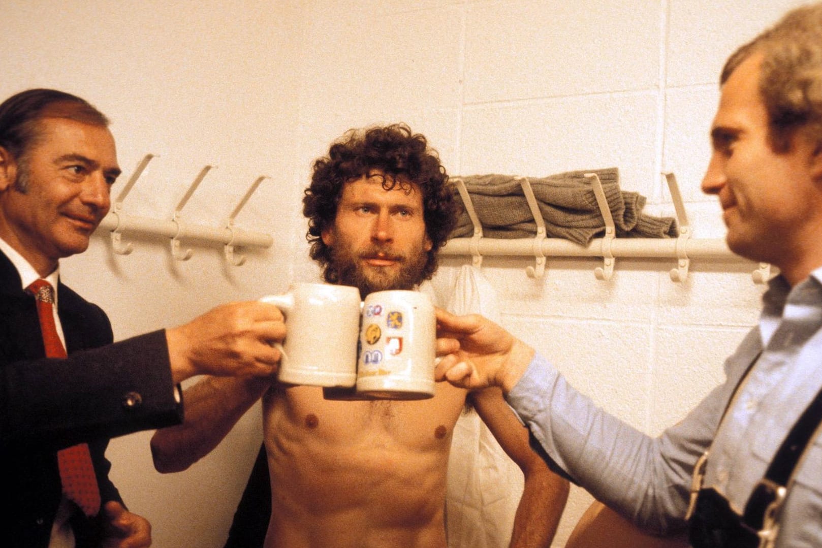 Trainer, Starspieler und Manager: Pal Csernai (v. l.), Paul Breitner und Uli Hoeneß stoßen in der Umkleidekabine des FC Bayern auf den Gewinn der Deutschen Meisterschaft 1980 an.