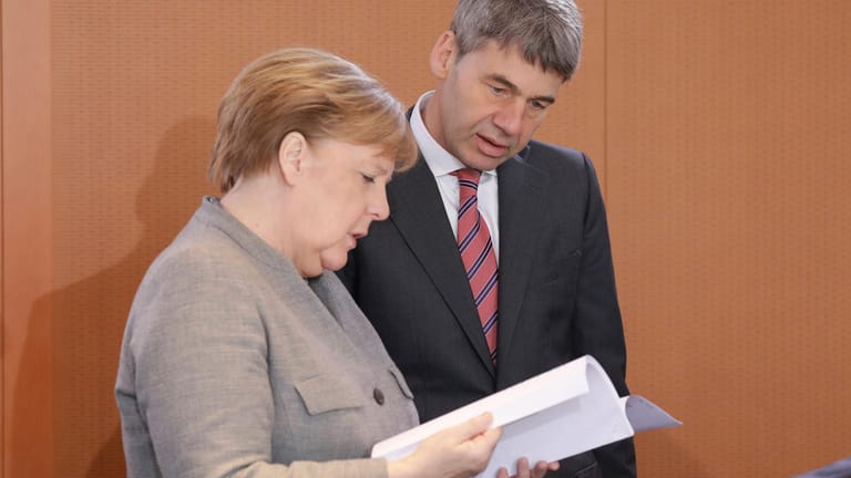 Jan Hecker schaut mit Angela Merkel in Unterlagen (Archivbild). Der deutsche Botschafter in China ist überraschend gestorben.