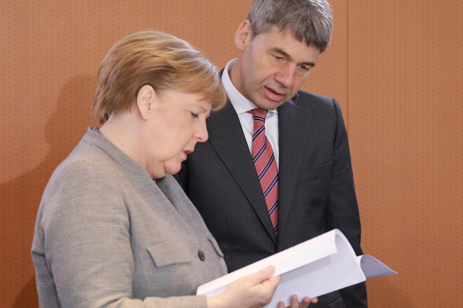 Jan Hecker schaut mit Angela Merkel in Unterlagen (Archivbild). Der deutsche Botschafter in China ist überraschend gestorben.