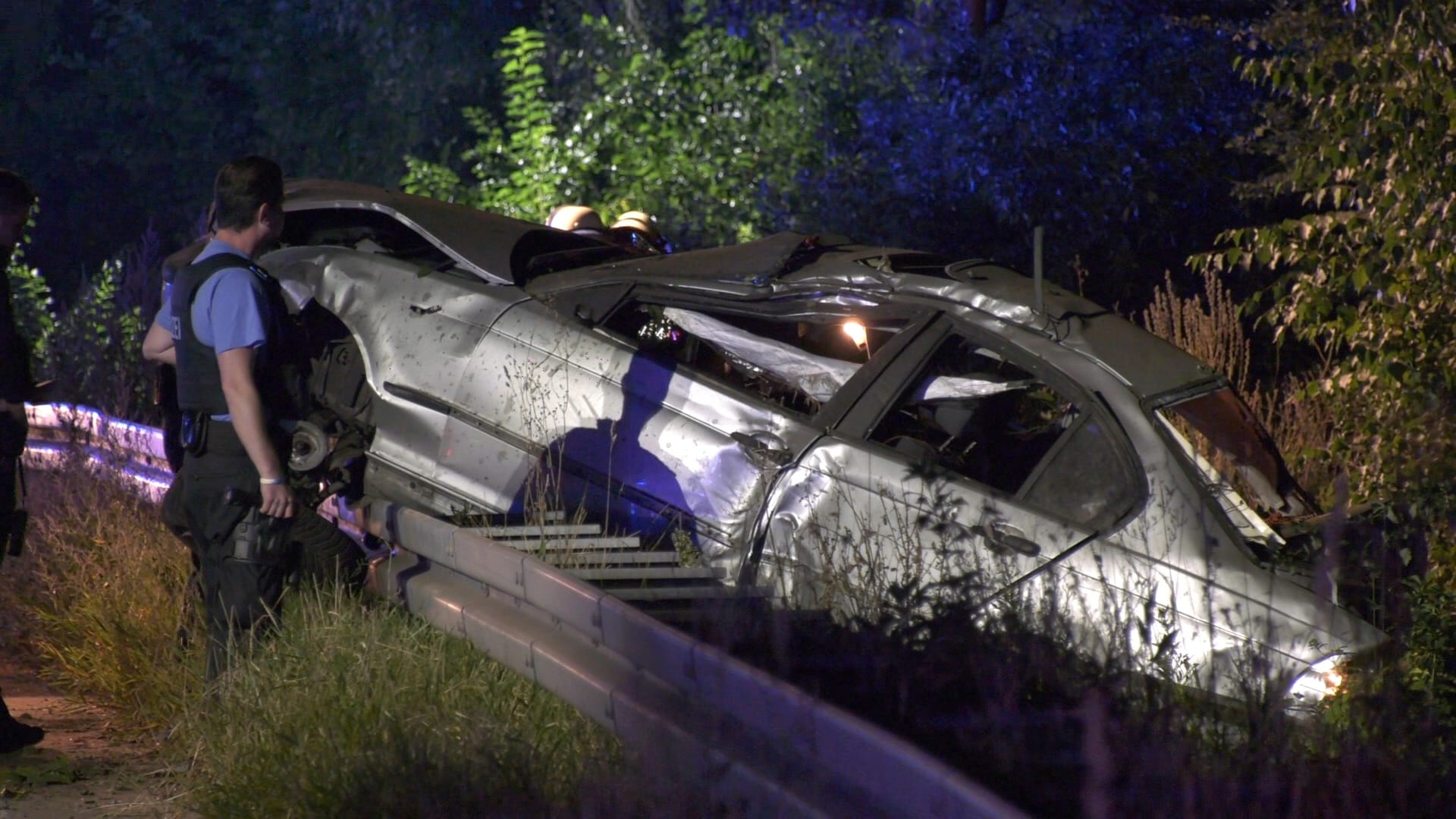 Ein Polizist untersucht das Wrack eines Pkw: In Rüsselsheim ist ein 19-Jähriger bei einem Unfall gestorben.