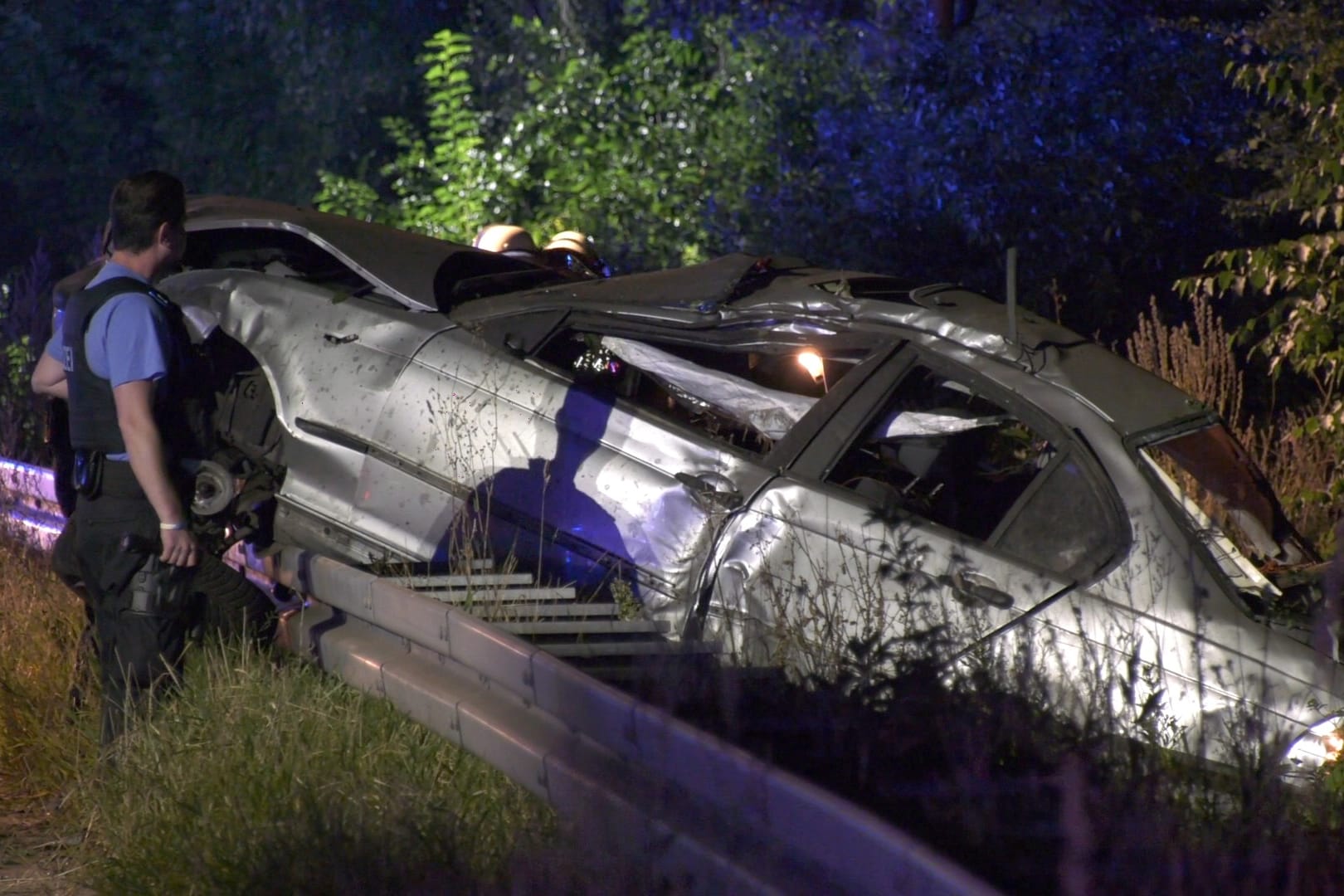 Ein Polizist untersucht das Wrack eines Pkw: In Rüsselsheim ist ein 19-Jähriger bei einem Unfall gestorben.