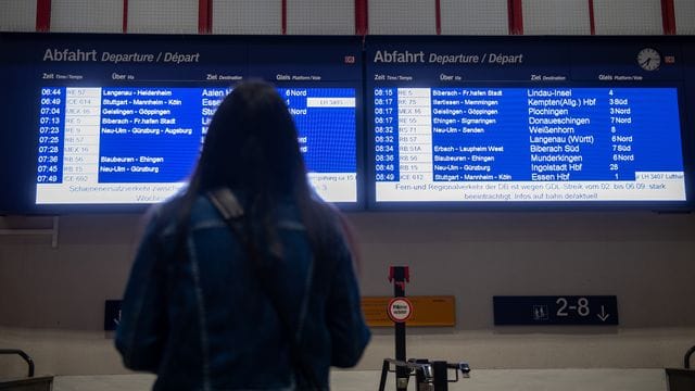 Eine Frau blickt auf eine Anzeigentafel am Hauptbahnhof Ulm