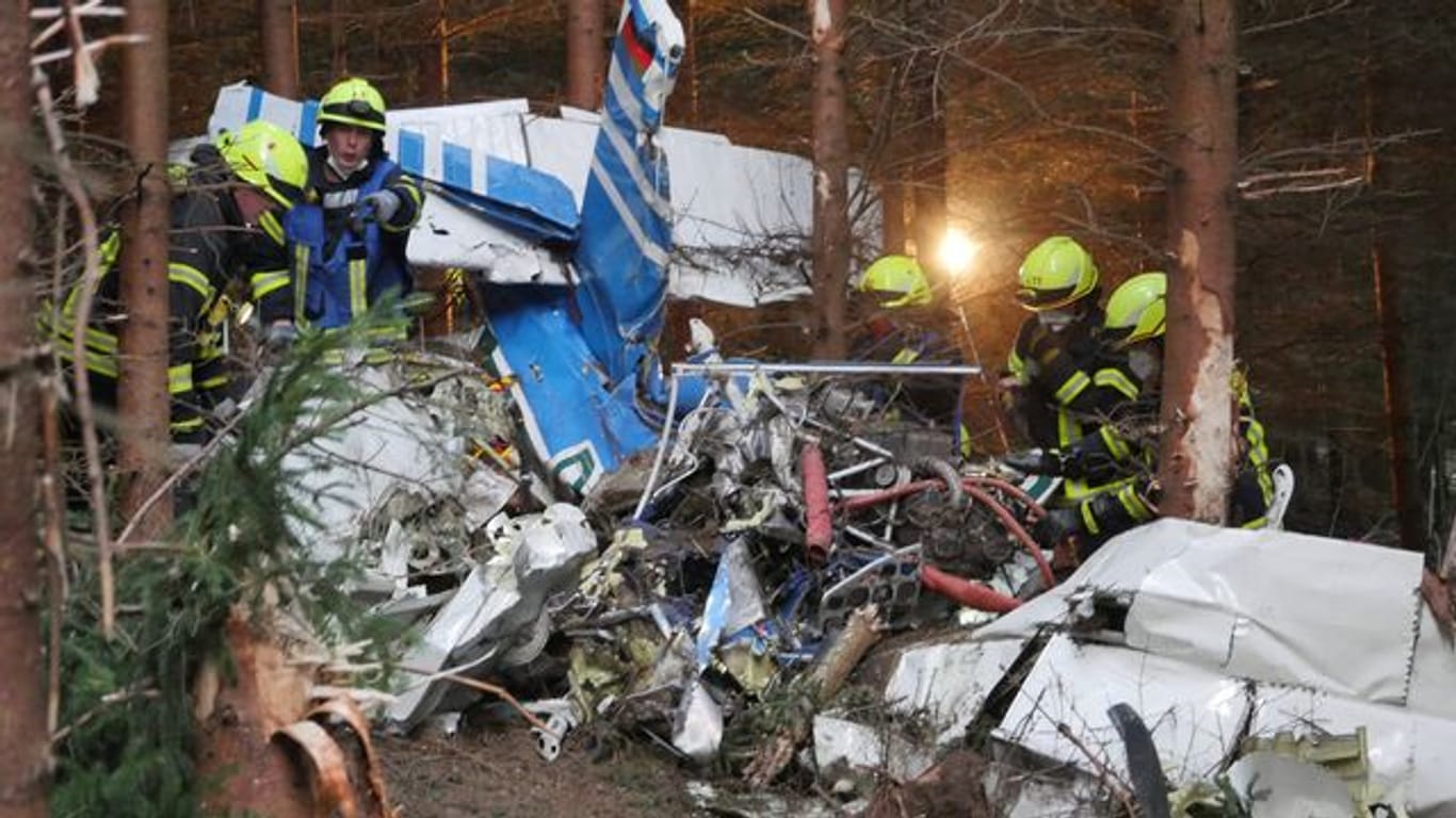 Unfallort in Wilnsdorf: Einsatzkräfte arbeiten am Wrack des abgestürzten Kleinflugzeugs.