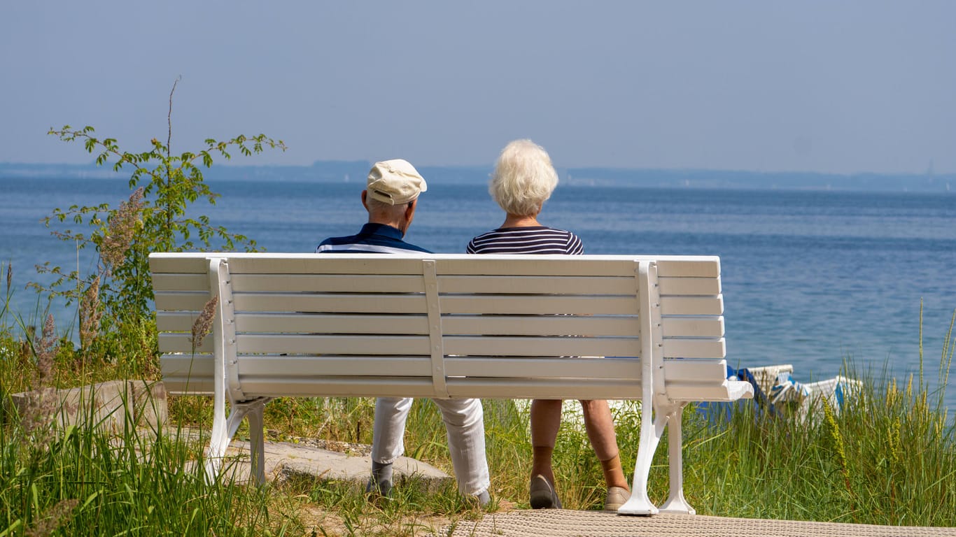 Ein älteres Paar auf einer Bank am Strand: Immer mehr Deutsche sorgen mit Wertpapieren fürs Alter vor.