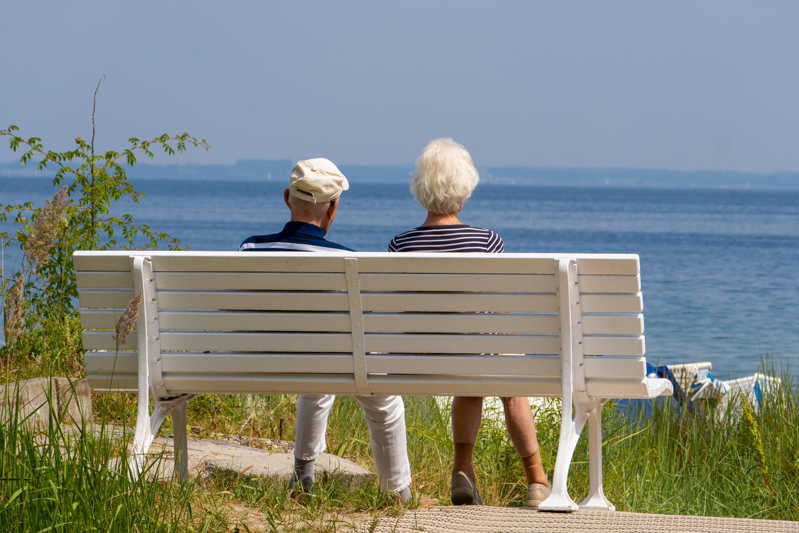 Ein älteres Paar auf einer Bank am Strand: Immer mehr Deutsche sorgen mit Wertpapieren fürs Alter vor.