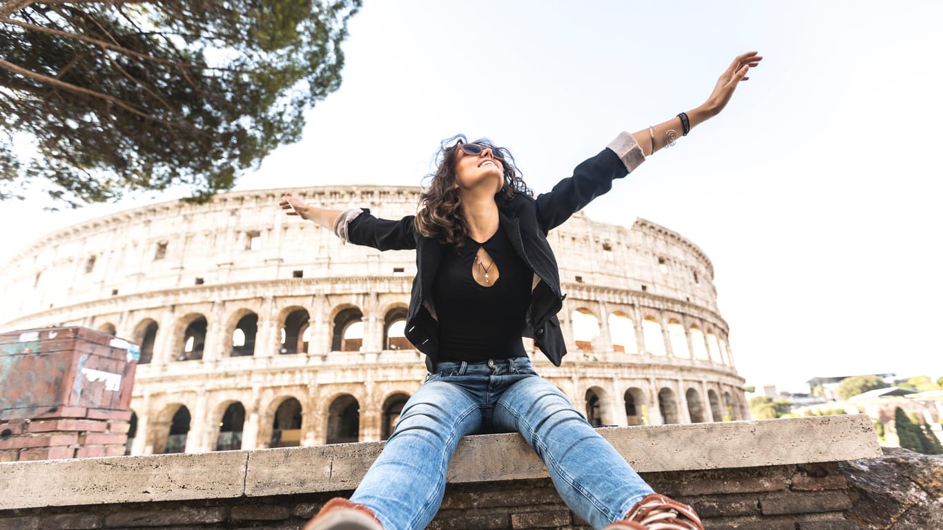 Land im Glück: Eine junge Frau vor dem Colosseum.