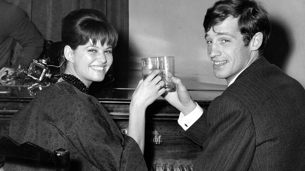 Der französische Schauspieler Jean-Paul Belmondo und die italienische Schauspielerin Claudia Cardinale stoßen an (1960). Der französische Schauspieler Jean-Paul Belmondo und die italienische Schauspielerin Claudia Cardinale stoßen an (1960).
