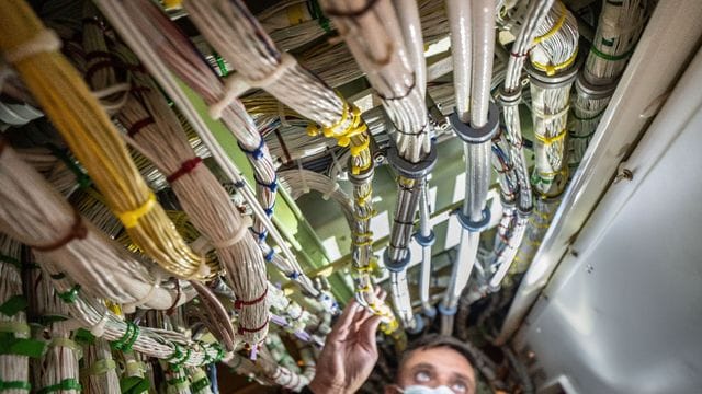 Ein Fluggerät-Elektroniker überprüft in der Lufthansa-Werft am Frankfurter Flughafen Kabelstränge im "Herz" einer Boeing.