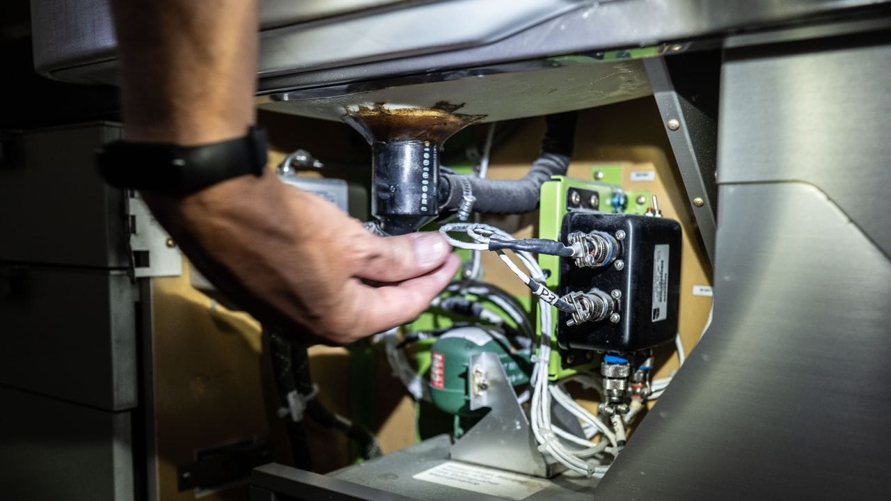 Als Fluggeräteelektroniker braucht es eine ruhige Hand: Hier wird in der Kabine einer Maschine ein Kabel unter einem Waschbecken geprüft.