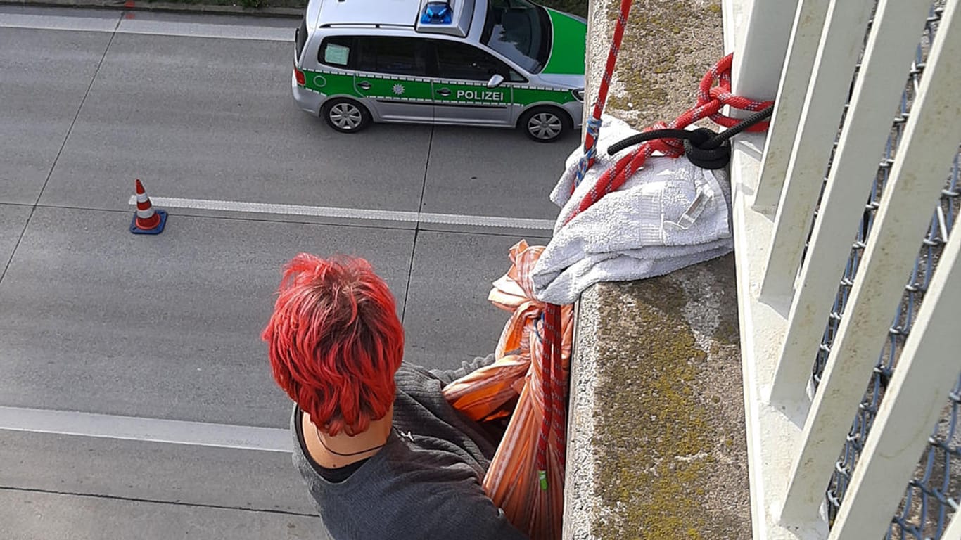 Blockade im September 2021 (Archivfoto): Eine Aktivistin hängt unter einer Brücke, die über die Autobahn 94 bei München führt.