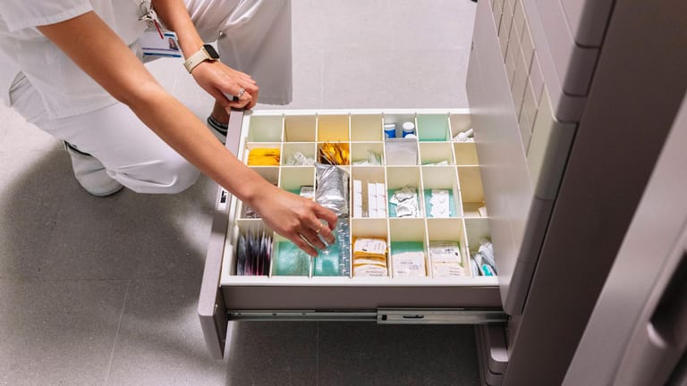 Eine Frau sucht nach Medikamenten in einer Schublade in einer Arztpraxis (Symbolbild): Eine ehemalige Mitarbeiterin einer Praxis wird verdächtigt, unberechtigt Medikamente bestellt zu haben.