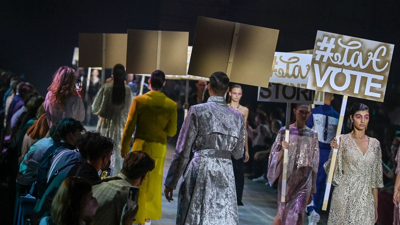 Models zeigen Kreationen des Designers Kilian Kerner bei der Mercedes-Benz Fashion Week im Kraftwerk und tragen dabei Plakate. Models zeigen Kreationen des Designers Kilian Kerner bei der Mercedes-Benz Fashion Week im Kraftwerk und tragen dabei Plakate.