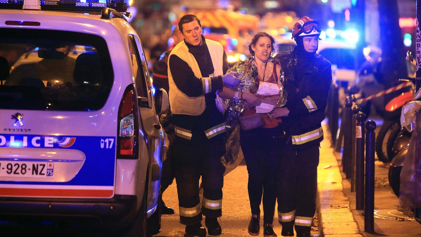 Rettungskräfte bringen eine Frau in Sicherheit: Bei der Attacke in Paris wurden 130 Menschen getötet.