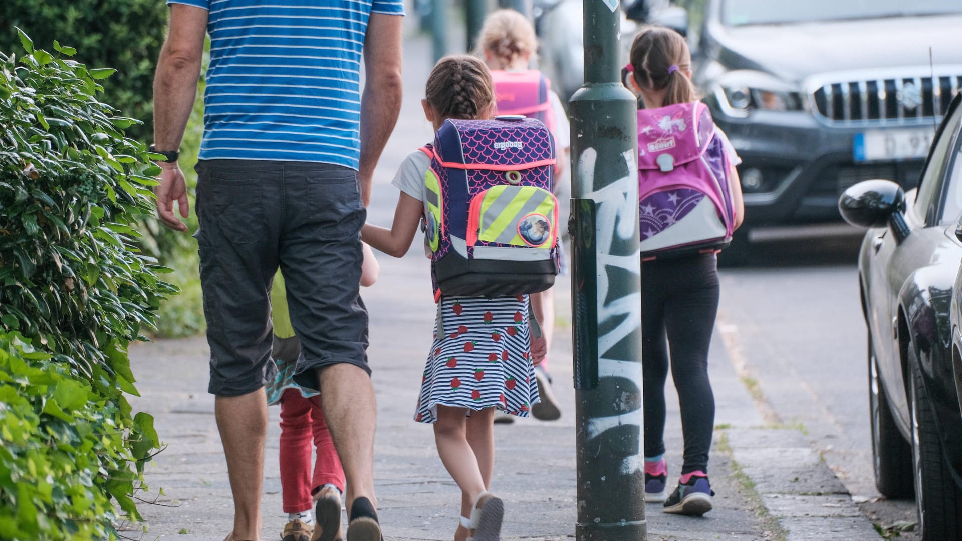 Ein Mann geht mit Kindern (Symbolbild): In Berlin wird gegen einen Kita-Mitarbeiter ermittelt.