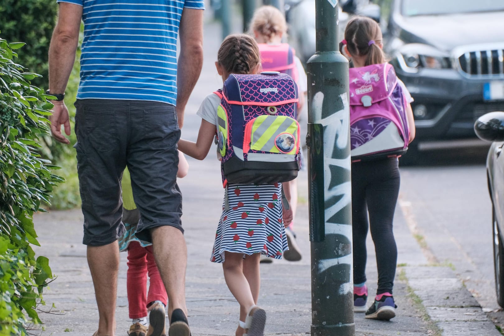 Ein Mann geht mit Kindern (Symbolbild): In Berlin wird gegen einen Kita-Mitarbeiter ermittelt.