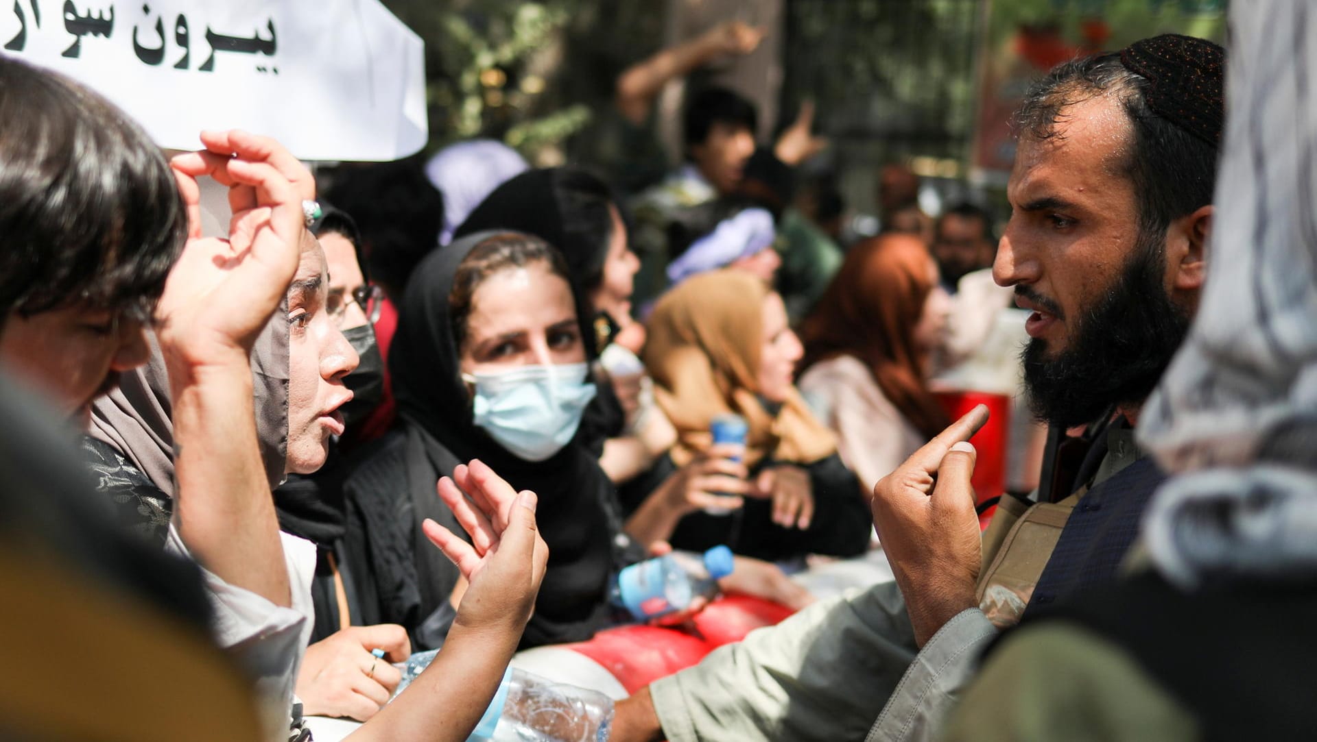 Demonstrantinnen sprechen mit Taliban-Kämpfern: Immer wieder gehen in diesen Tagen Frauen auf die Straße.