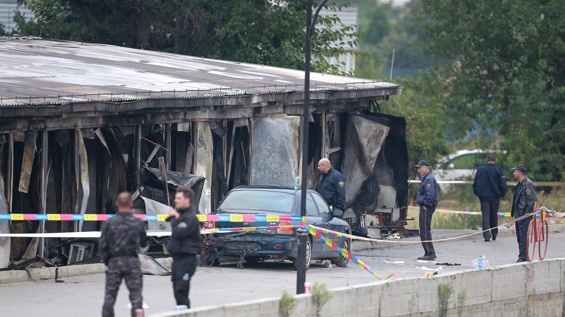 Nordmazedonien, Tetovo: Polizisten sichern den Bereich, in dem ein Forensikteam nach einem Brand in einem zerstörten Feldlazarett ermitteln soll. Nordmazedonien, Tetovo: Polizisten sichern den Bereich, in dem ein Forensikteam nach einem Brand in einem zerstörten Feldlazarett ermitteln soll.