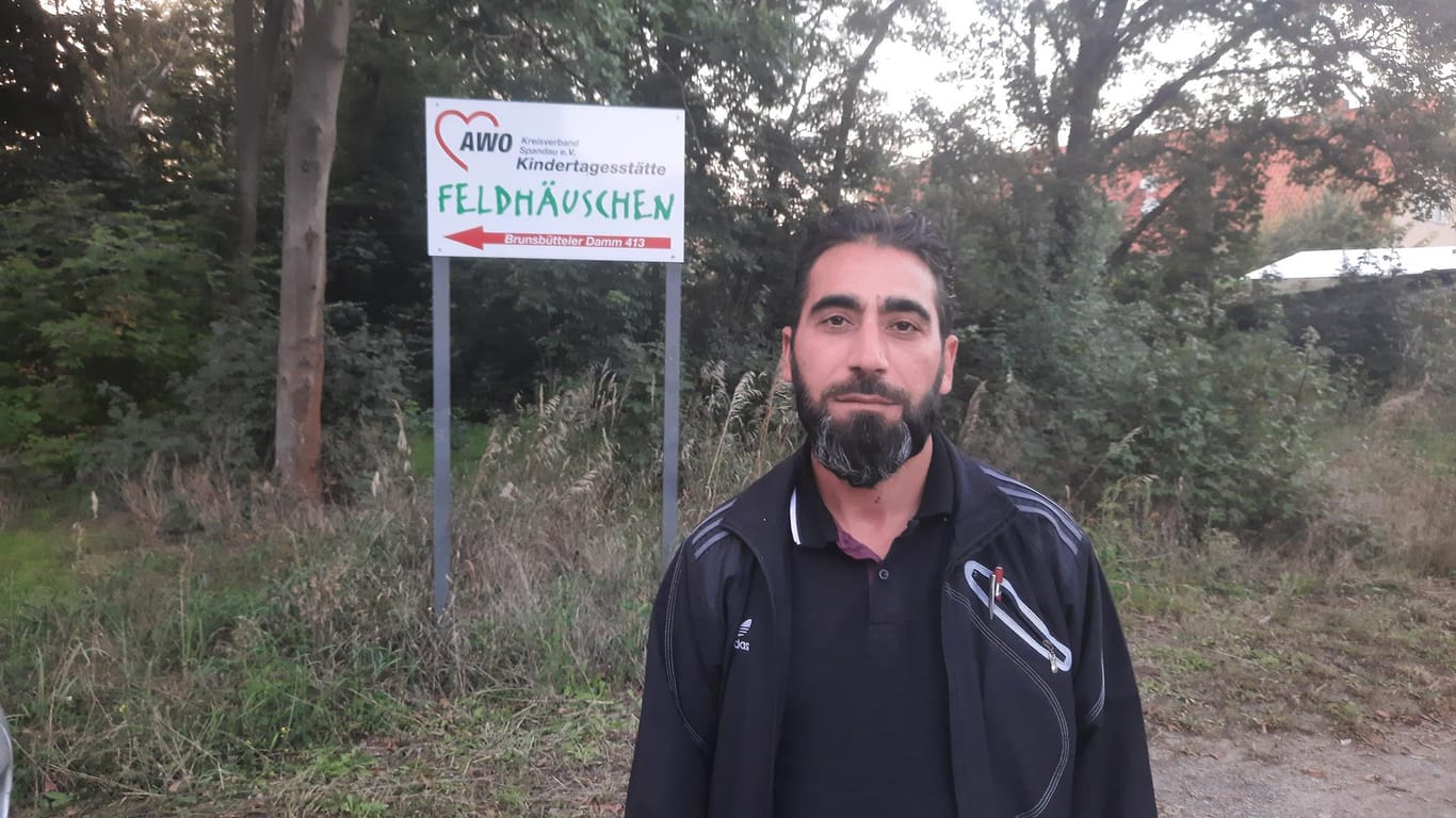 Vater Mehmet Yilmaz steht vor dem Schild der Kindertagesstätte seiner Tochter: Er will Auffälligkeiten an seinem Kind bemerkt haben.