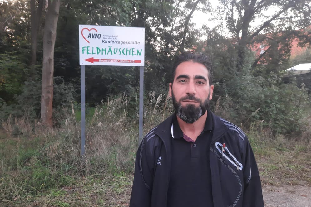 Vater Mehmet Yilmaz steht vor dem Schild der Kindertagesstätte seiner Tochter: Er will Auffälligkeiten an seinem Kind bemerkt haben.