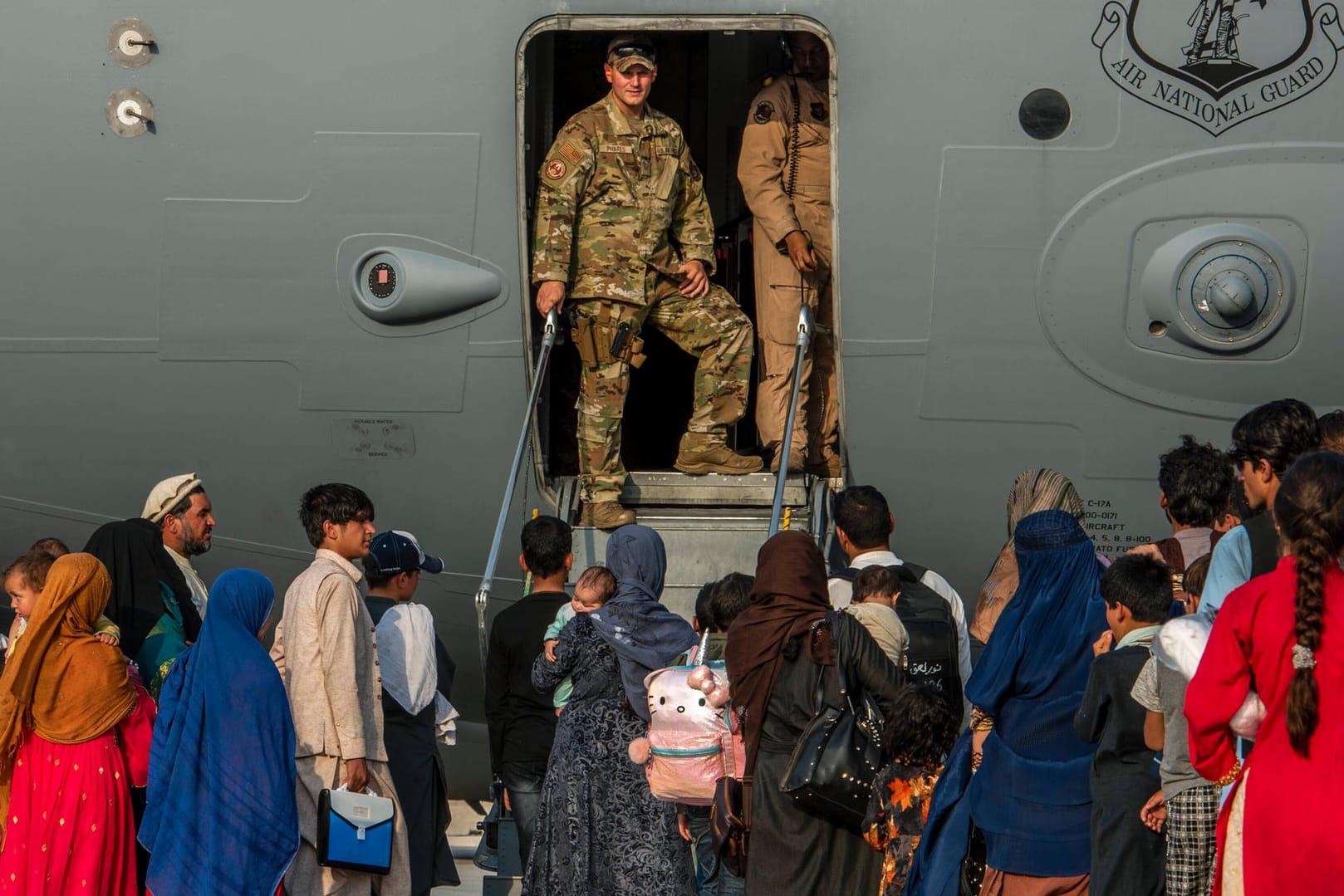 Afghanische Flüchtlinge steigen in ein Flugzeug auf der Militärbasis Al Udeid: Häufig haben sie kein Mitspracherecht über ihr Ziel.