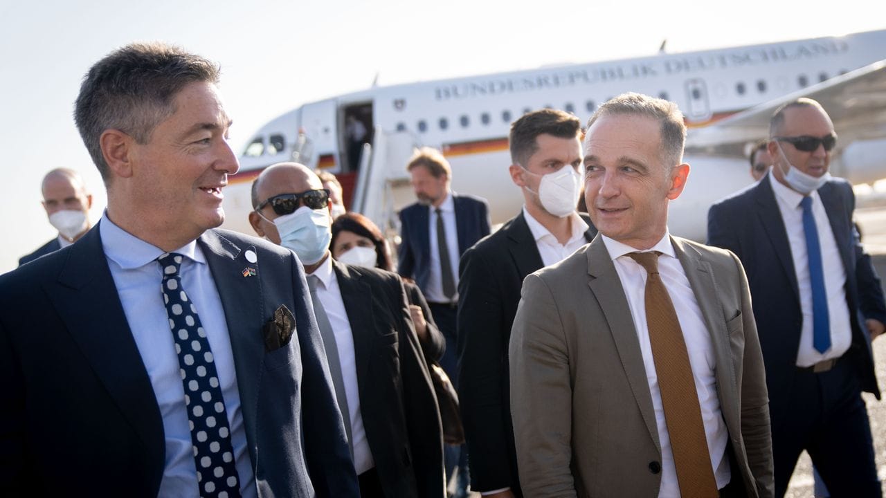Heiko Maas wird auf dem Flughafen der libyschen Hauptstadt vom neuen deutschen Botschafter Michael Ohnmacht (l) begrüßt.