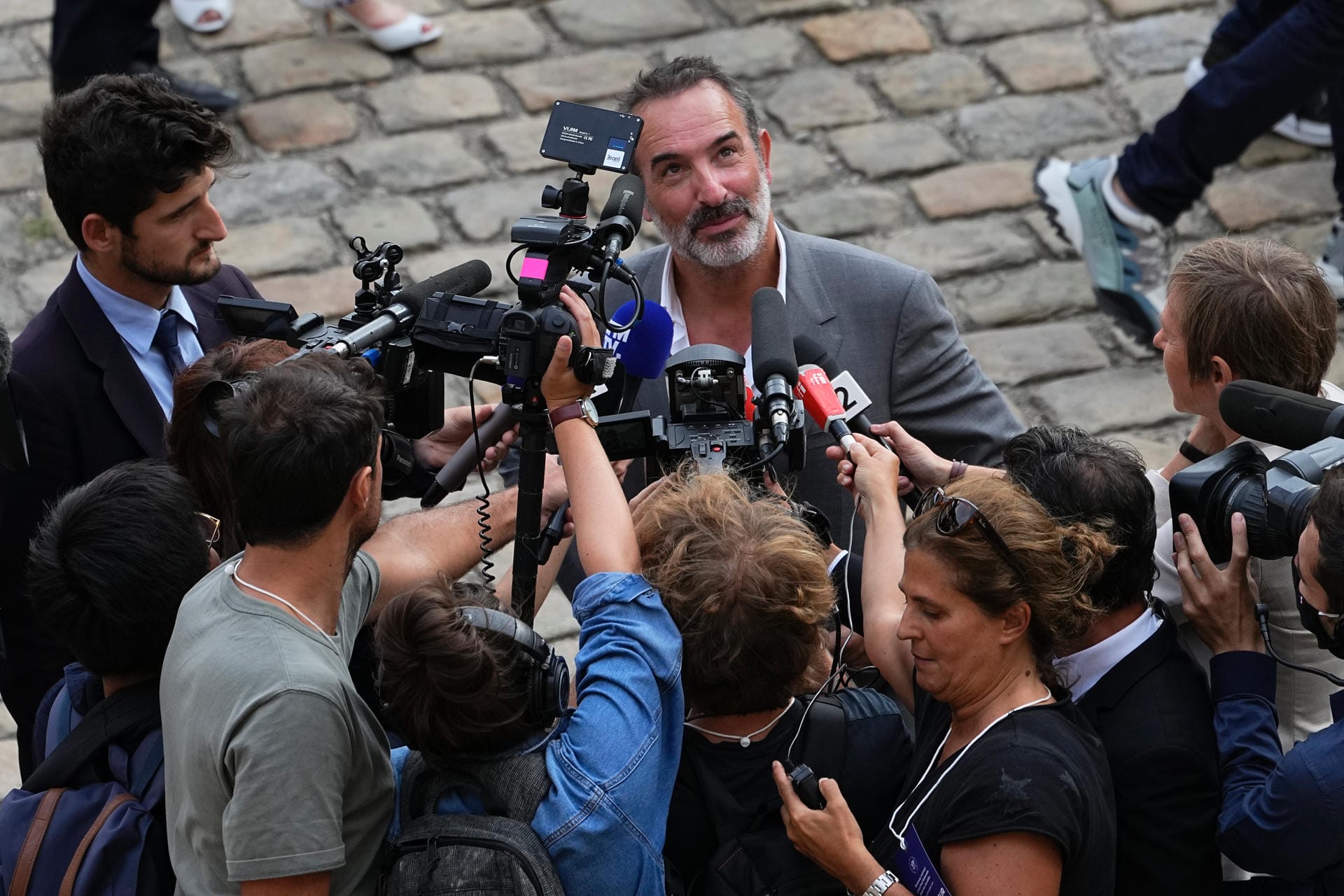 Jean Dujardin beantwortet Fragen von Reportern vor der Trauerfeier Belmondos.