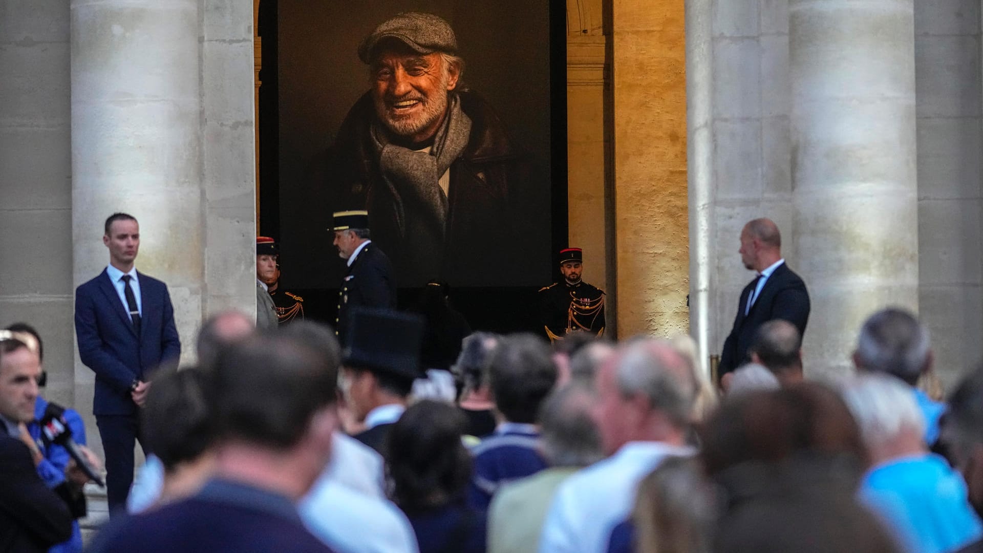 Menschen stehen an, um dem Sarg mit den sterblichen Überresten des französischen Schauspielers Jean-Paul Belmondo im Invalidendom zu sehen.