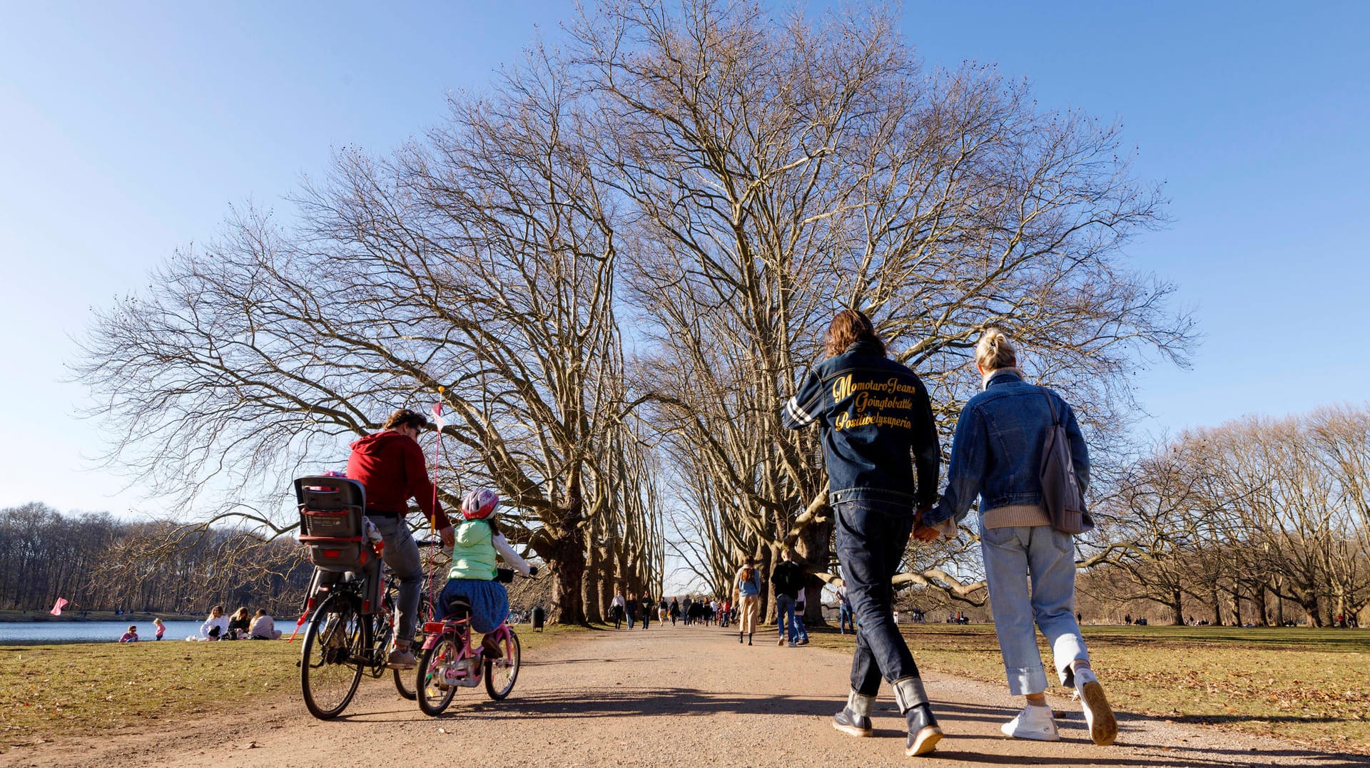 Kölner Passantinnen und Passanten am Decksteiner Weiher (Archivbild): Am Wochenende erlaubt das Wetter nochmal Ausflüge in und um Köln.