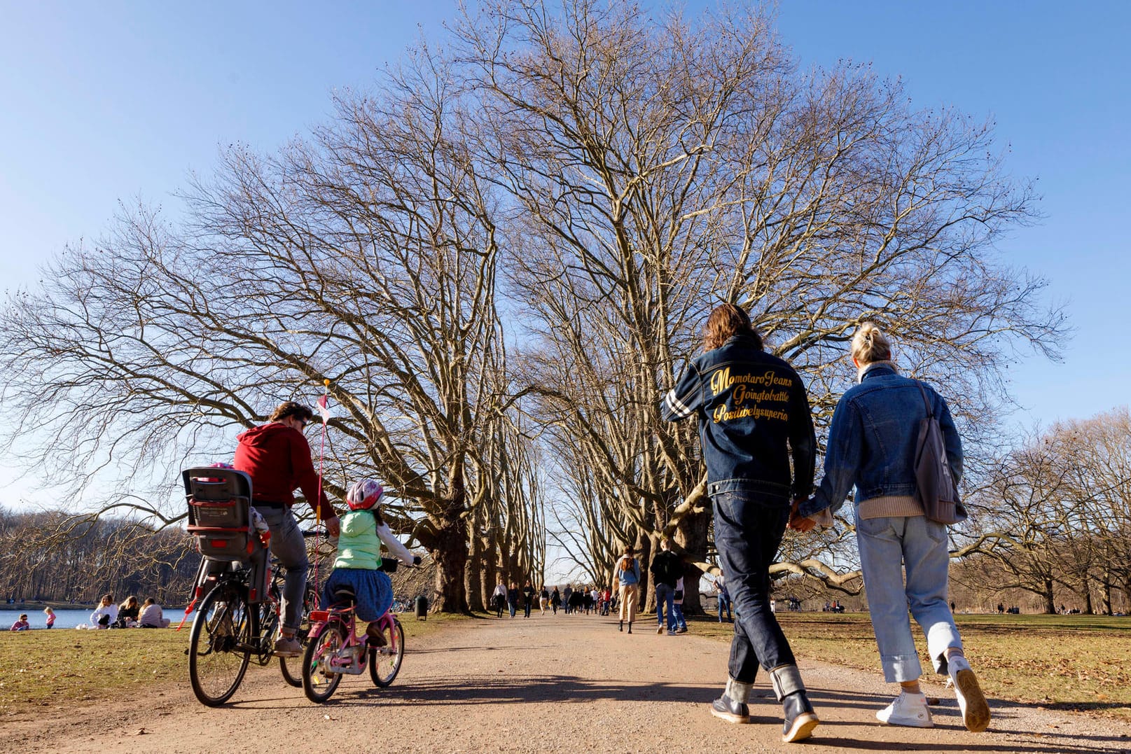 Kölner Passantinnen und Passanten am Decksteiner Weiher (Archivbild): Am Wochenende erlaubt das Wetter nochmal Ausflüge in und um Köln.