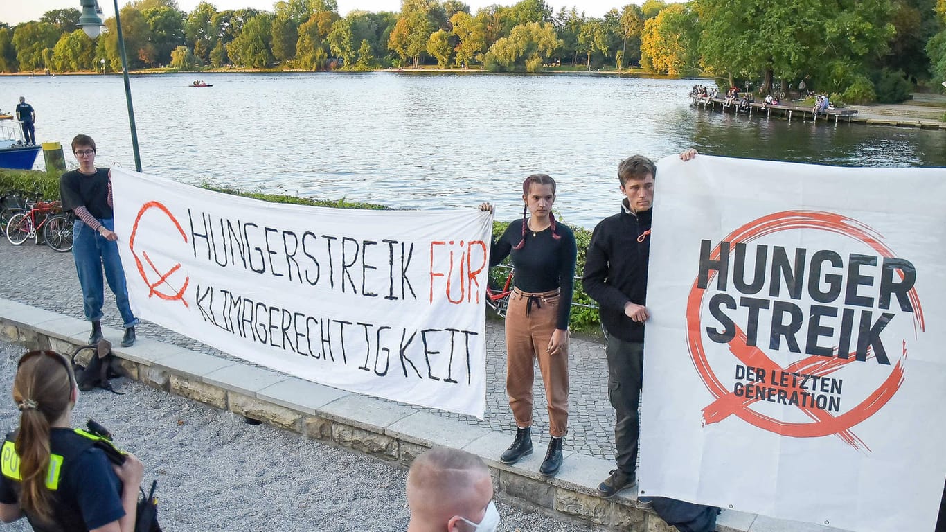 Demonstranten mit einem Plakat in der Hand protestieren mit einem Hungerstreik für "Klimagerechtigkeit": Henning Jeschke (zw. v. li.) hat seit mittlerweile über zwölf Tagen nichts mehr gegessen.