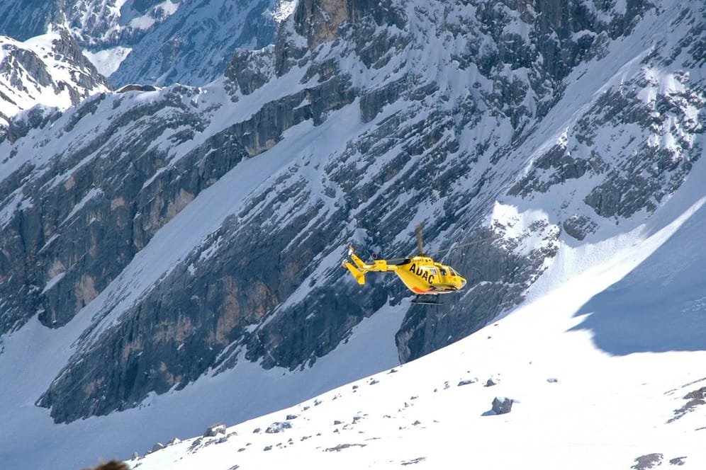 Ein Rettungshubschrauber des ADAC an der Zugspitze (Archivbild). Helfer mussten zwei Stunden lang suchen, bis sie einen abgestürzten Kletterer fanden.