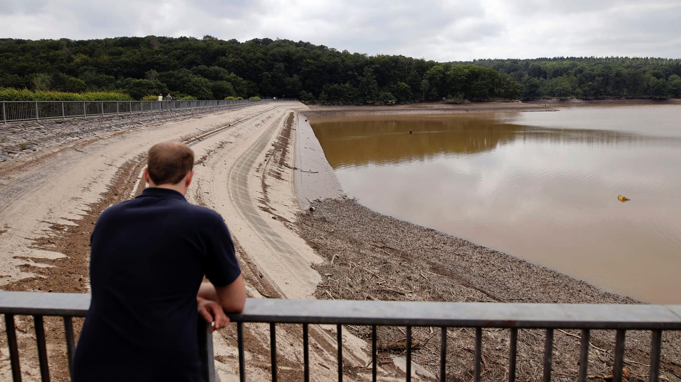 Ein Mann steht an der Steinbachtalsperre im Kreis Euskirchen (Archivbild): Die mentale Belastung der Flutopfer zeigt sich erst Wochen nach der Katastrophe.