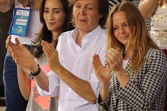 Paul McCartney (M) applaudiert mit seiner Frau Nancy Shevell und seiner Tochter Stella (r).