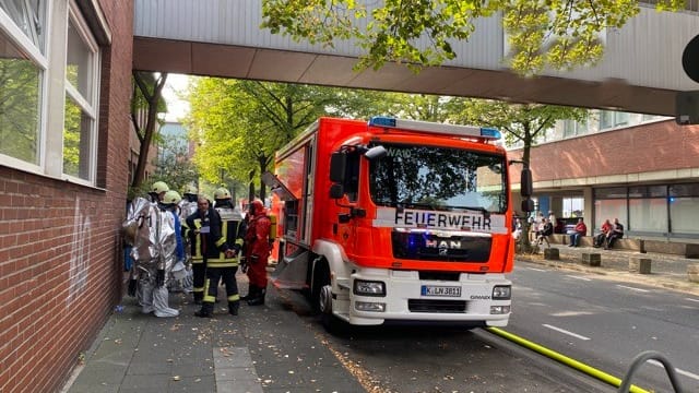 Feuerwehrleute stehen in Köln auf einer Straße: Dort untersuchen die Einsatzkräfte derzeit, woher ein auffälliger Geruch kommt. Feuerwehrleute stehen in Köln auf einer Straße: Dort untersuchen die Einsatzkräfte derzeit, woher ein auffälliger Geruch kommt.