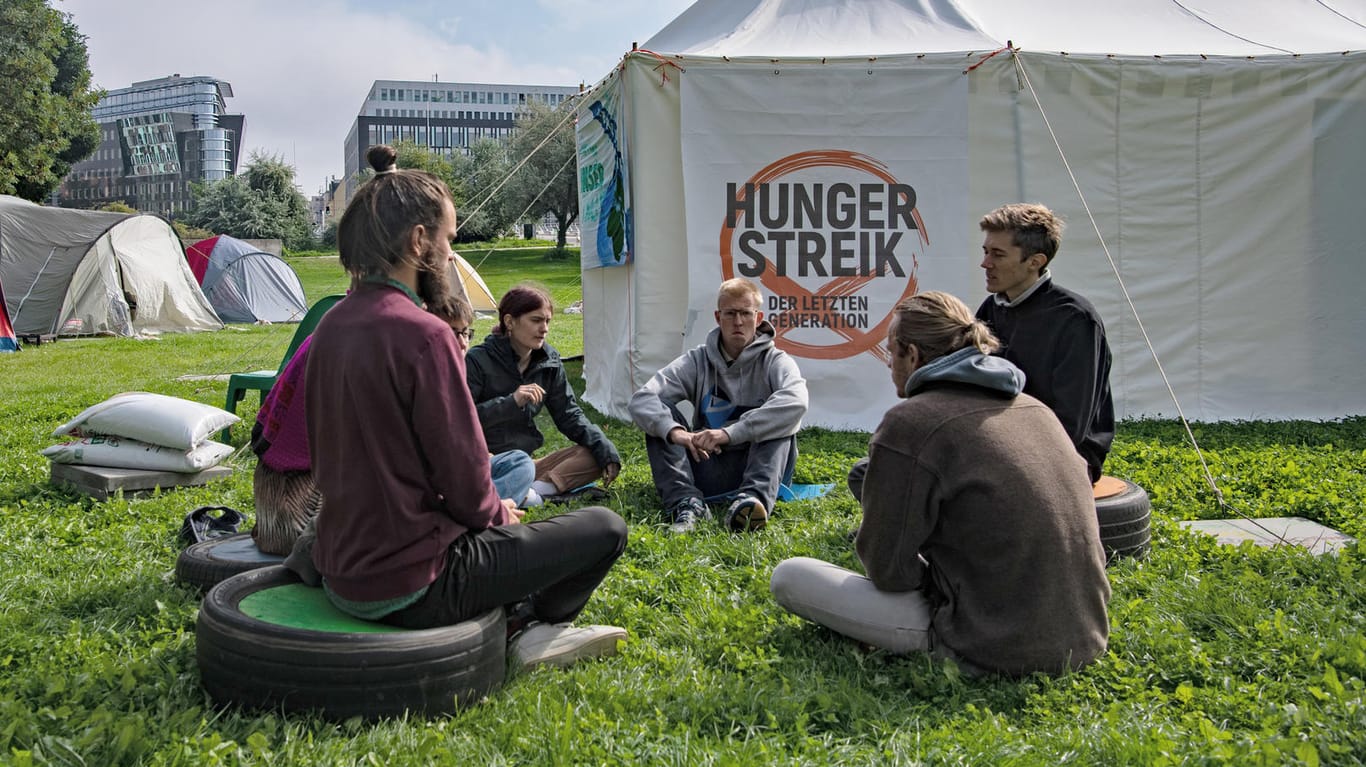 Umweltaktivisten sitzen im Regierungsviertel zusammen vor einem Zelt: Manche der Aktivisten haben seit zwei Wochen nichts gegessen und wollen nun sogar auf verdünnten Fruchtsaft verzichten.