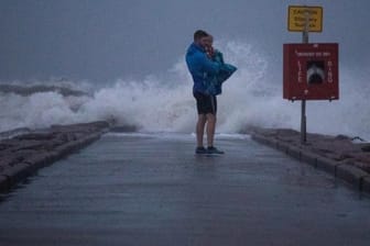 Ein Mann hält seinen Sohn an einem Pier in Texas: Der Tropensturm "Nicholas" ist zu einem Hurrikan hochgestuft worden.