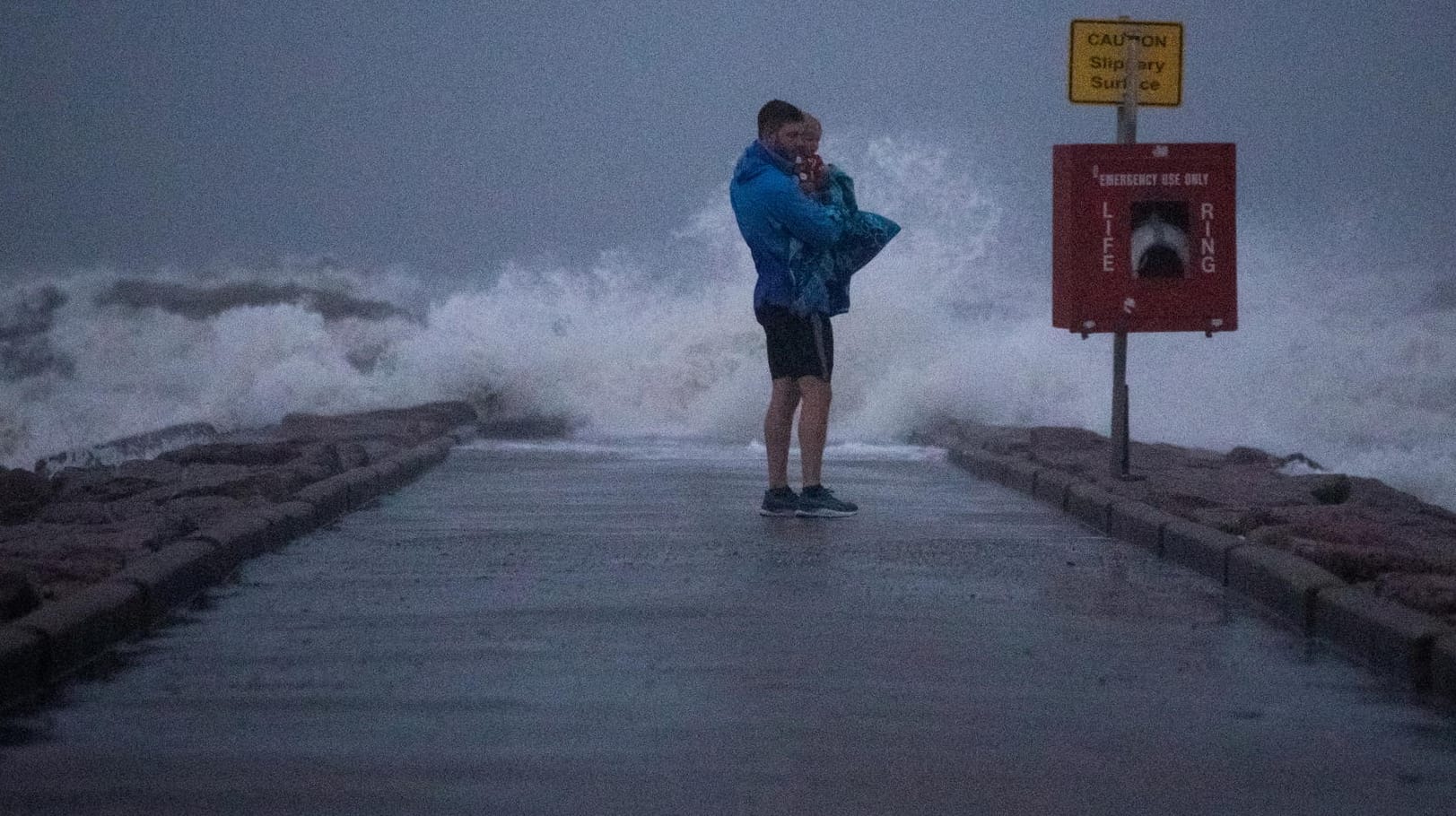 Ein Mann hält seinen Sohn an einem Pier in Texas: Der Tropensturm "Nicholas" ist zu einem Hurrikan hochgestuft worden.