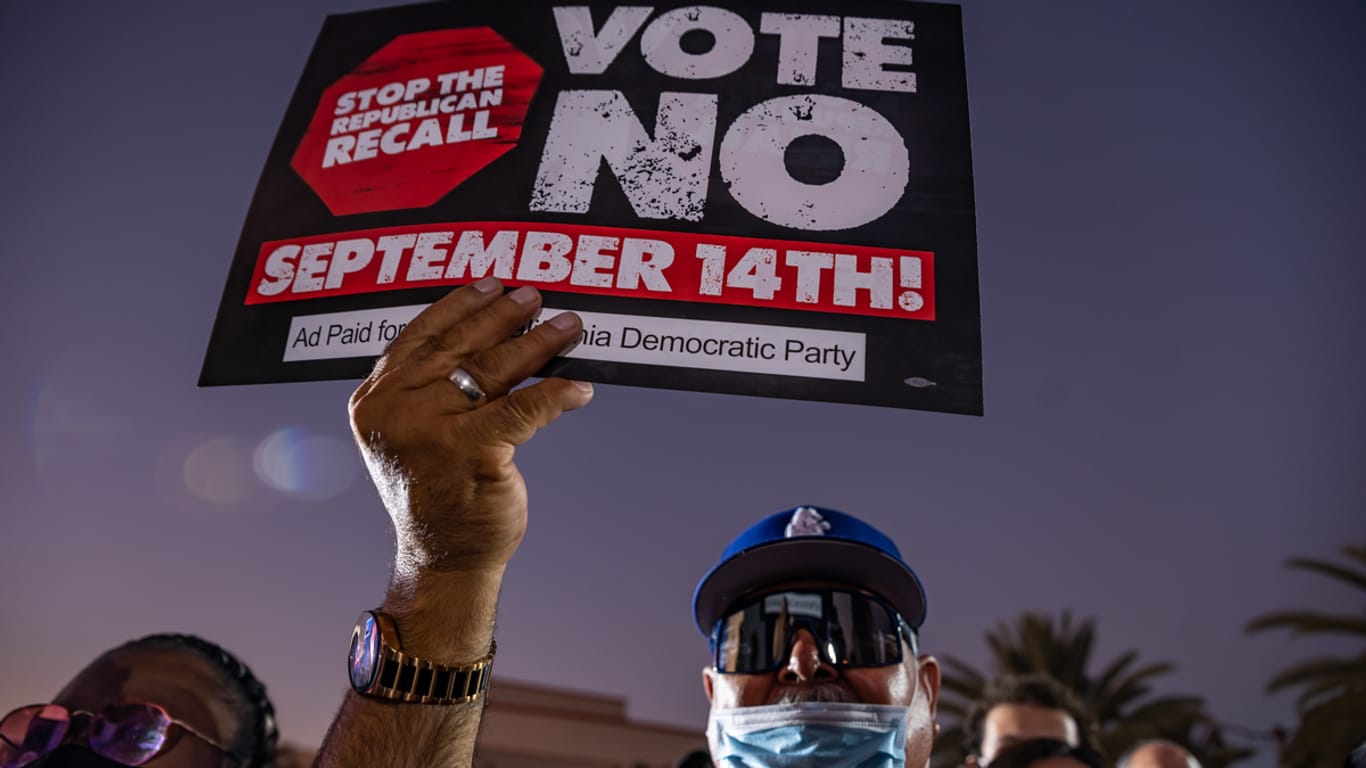 Ein Mann hält während einer Rede des US-Präsidenten Biden auf dem Long Beach City College Liberal Arts Campus ein Plakat mit der Aufschrift "Vote NO!" ("Wähle NEIN").