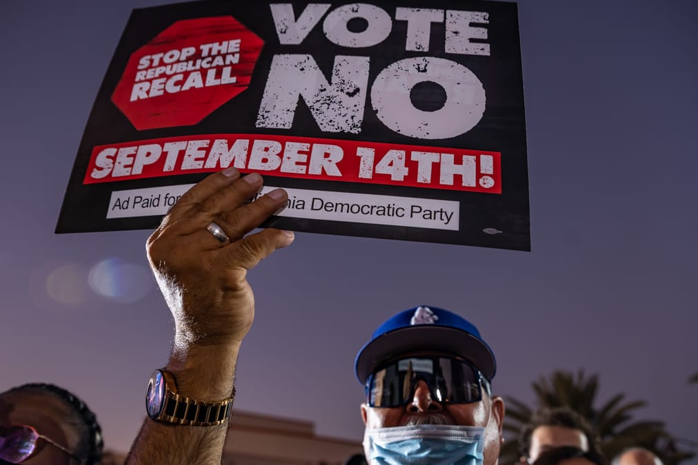 Ein Mann hält während einer Rede des US-Präsidenten Biden auf dem Long Beach City College Liberal Arts Campus ein Plakat mit der Aufschrift "Vote NO!" ("Wähle NEIN").