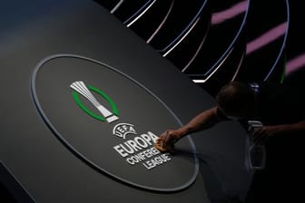 Ein Mitarbeiter reinigt das Logo der UEFA Europa Conference League.