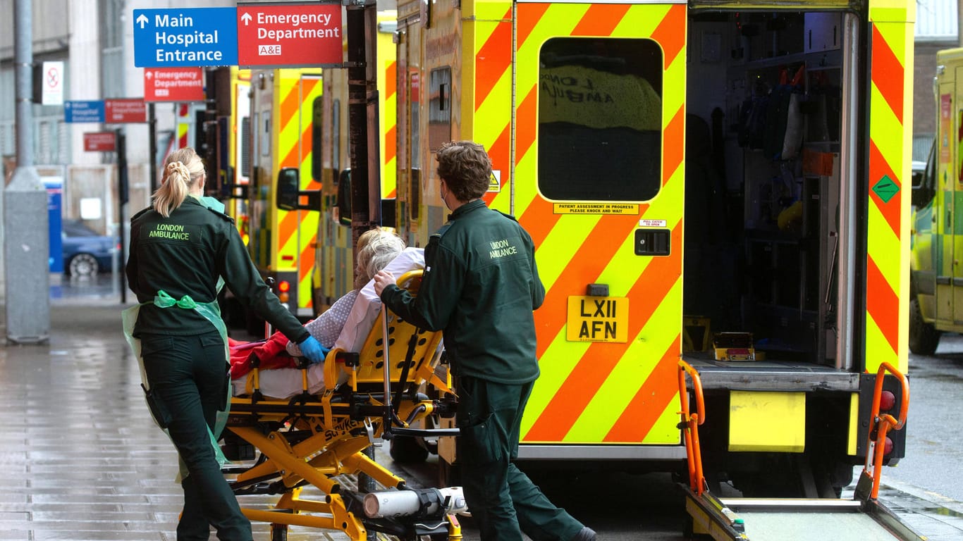 Notfallsanitäter rollen eine Trage in ein Krankenhaus (Symbolbild): Auch im britischen Gesundheitssystem besteht ein akuter Personalmangel.