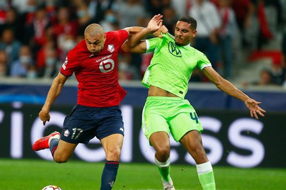 Maxence Lacroix vom VfL Wolfsburg (r) kann sich im Kampf um den Ball nicht gegen Burak Yilmaz vom OSC Lille durchsetzen.