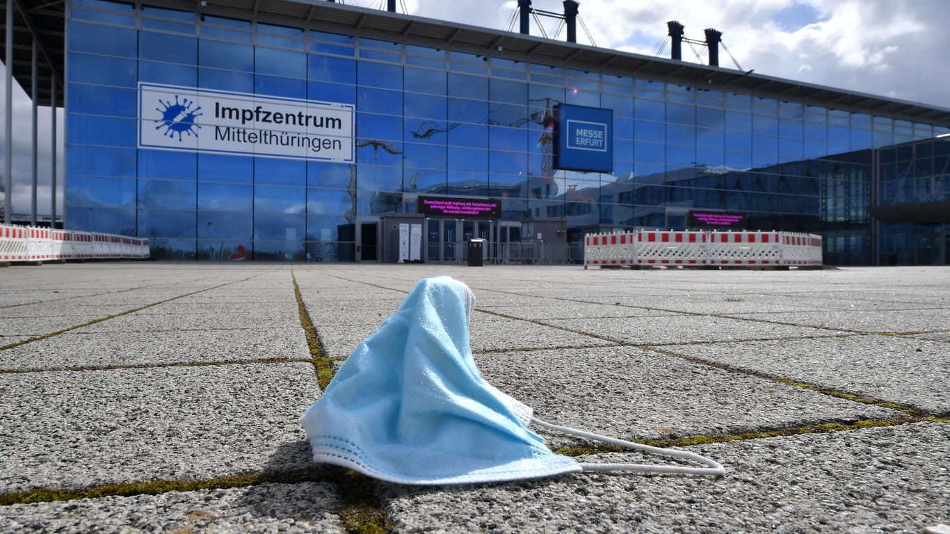 Eine Maske liegt vor dem Impfzentrum in der Messe Erfurt: Der bundesweite Inzidenzwert sinkt derzeit wieder.