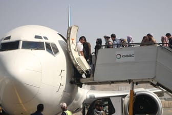 Menschen steigen am Kabuler Flughafen in ein Flugzeug: Etwa 2.600 Menschenrechtler, Künstler, Wissenschaftler, Journalisten und andere potenziell gefährdete Menschen kommen nach Deutschland.