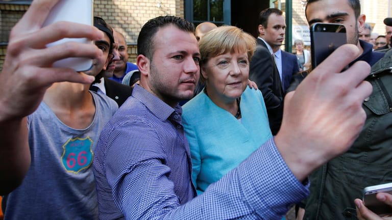 Angela Merkel lässt sich im September 2015 mit Flüchtlingen aus Syrien und dem Irak fotografieren: Wie steht es um die Integration der Menschen, die damals nach Deutschland kamen?