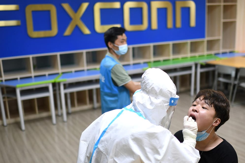 Halsabstrich beim Apple-Zulieferer Foxconn: Chinesische Arbeiter müssen sich regelmäßig auf Corona testen lassen.
