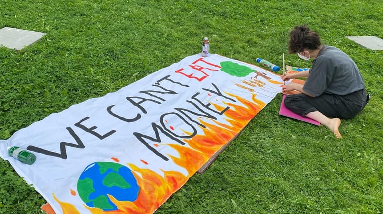 "We Can't Eat Money" (dt. Wir können kein Geld essen) steht auf einem Plakat: Klimaaktivistinnen und -aktivisten wollen mit einem Hungerstreik erreichen, dass die Kanzlerkandidierenden von SPD, CDU und Grüne mit ihnen sprechen.